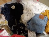 a suitcase full of clothes and clothes sitting on the floor