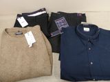 three pairs of men ' s sweaters and pants sitting on a couch