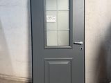 une porte grise avec une vitre dans une pièce