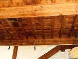 a room with a wooden ceiling and a white wall