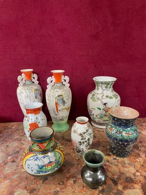 many vases sitting on a table with a red wall behind them