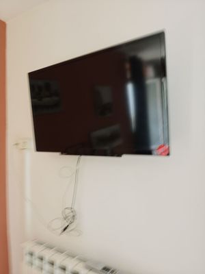 a flat screen tv mounted on the wall above a radiator