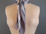 grey and white scarf on a mannequin torso