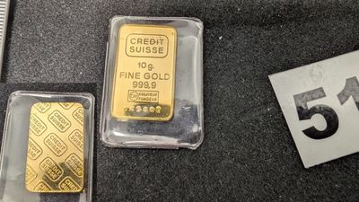 Trois lingots d'or sont posés les uns à côté des autres sur une table