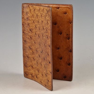 an ostrich leather wallet with a small hole in the middle