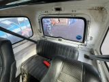 a seat in the back of a truck with a window open