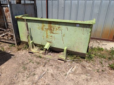une boîte métallique verte posée par terre