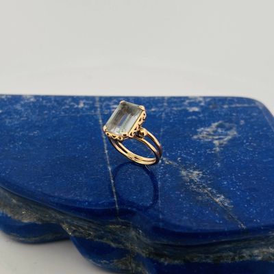 a close up of a blue stone with a gold ring on top of it