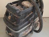 a vacuum that is sitting on the floor next to a wall