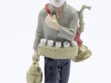 a figurine of a man with a pipe and a bag