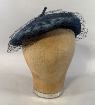 chapeau bleu marine avec de la maille, posé sur la tête d'un mannequin