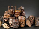 many wooden masks that are sitting on a black surface