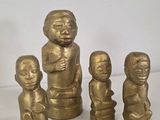 brass figurines of a family of five sitting on a white surface