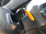 a yellow keychain hanging from the steering wheel of a car