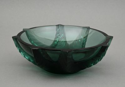 un saladier en verre vert posé sur une table