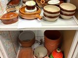 de nombreux bols et casseroles sur une étagère dans la cuisine