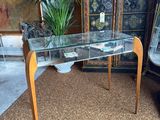 a glass table with a plant on it in the middle of a room