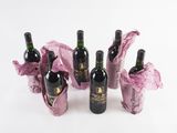 several bottles of wine sitting on top of a table covered in pink tissue