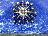 une broche ancienne en argent, ornée de perles et d'étoiles sur une pierre bleue