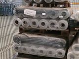 many rolls of plastic sitting on a pallet in a warehouse