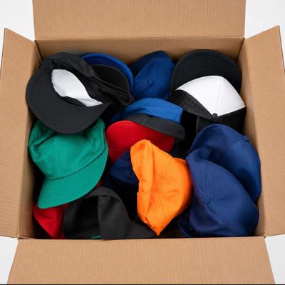 une boîte en carton remplie de chapeaux de toutes les couleurs