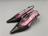 a pair of women ' s black shoes with a pink heel