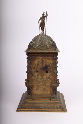 une horloge en bronze surmontée d'une statue