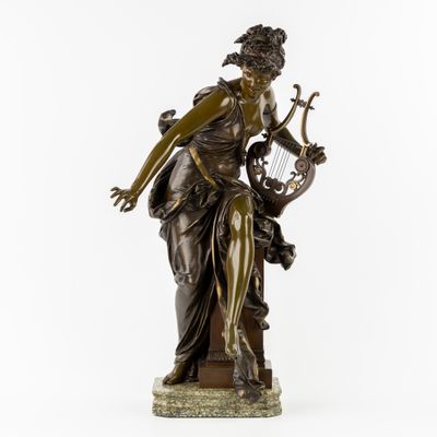 une statue en bronze représentant une femme tenant une harpe