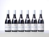 six bottles of red wine lined up in a row on a table