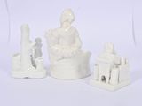 a white figurine of a woman sitting on a chair
