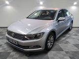 La Volkswagen Passat est garée dans une grande pièce au sol carrelé en damier.