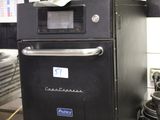 a black oven sitting on top of a metal counter