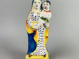 figurine représentant une femme tenant un enfant dans ses bras, coiffée d'une couronne
