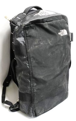 un sac à dos noir posé contre un mur