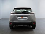 the rear end of a silver car in a white room