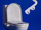 des toilettes blanches sur lesquelles est posée une clé, avec un mur bleu en arrière-plan