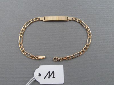un gros plan d'un bracelet en or auquel est attachée une étiquette