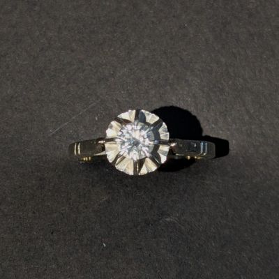 a close up of a diamond ring on a black surface