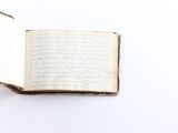 an old open book with writing on it sitting on top of a table