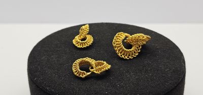 un gros plan sur une paire de boucles d'oreilles posées sur une boîte noire