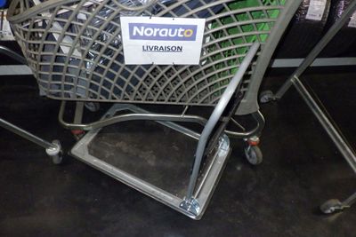 un caddie sur lequel est accrochée une affiche, dans un magasin