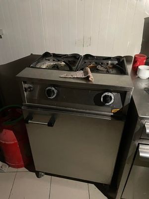a silver stove top oven sitting in a kitchen next to a sink