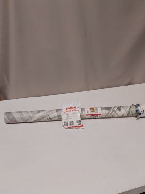 une vieille batte de baseball posée sur une table, à côté d'un rouleau de papier