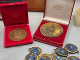 a box of medals and a box of coins on a table