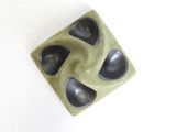a green and black object on a white surface