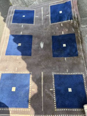 someone is sitting on the floor with a blue rug on it