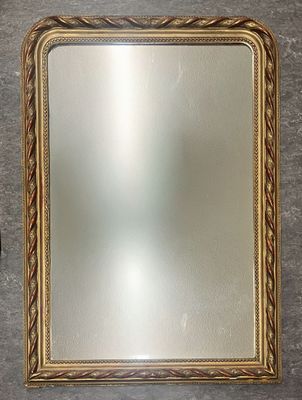 un miroir à cadre doré sur un mur gris avec un mur blanc