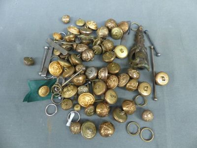 un tas de boutons en or et une paire de ciseaux posés sur une table