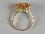 an image of a gold ring with an orange stone in it