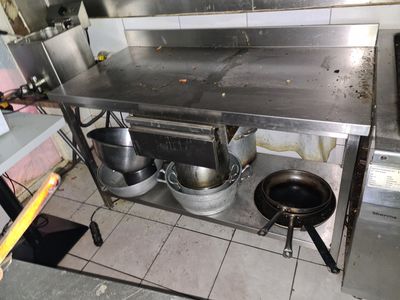 a large stainless steel table with pots and pans on it